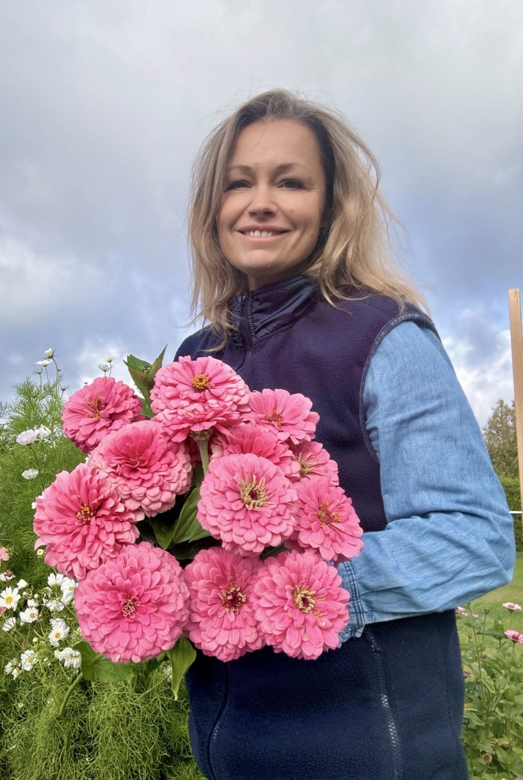 Erica Nilsson, grundare av Palettparadiset, med rosa zinnior i odlingen på Öland